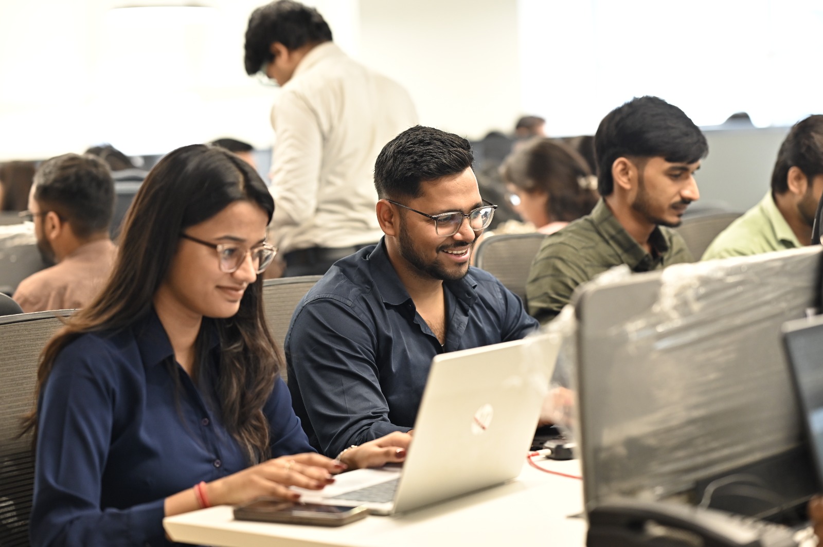 Two V. V. Kale colleagues working together at a laptop